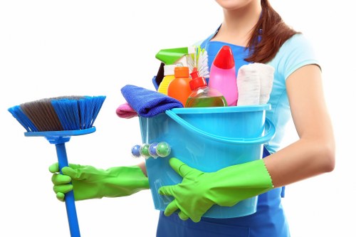 Cleaning staff maintaining shared office kitchen and communal surfaces